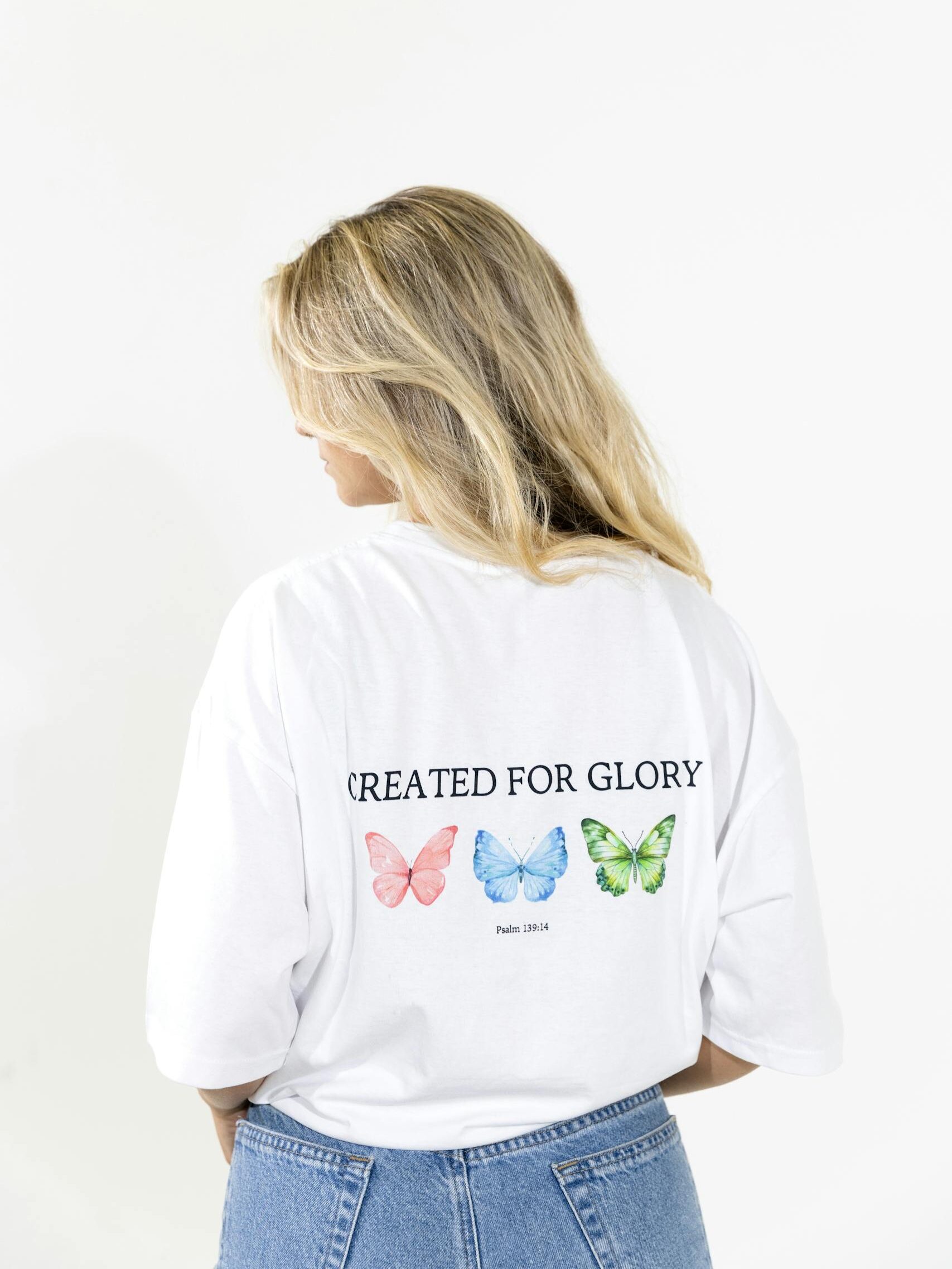 Woman wearing a creative butterfly print t-shirt with vibrant colors.